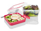 Een roze lunchbox met salade, mozzarella en dressing.