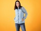 Een vrouw draagt een blauwe donsjas en jeans.