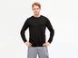 Man draagt een zwarte sweater met grijze trainingsbroek.