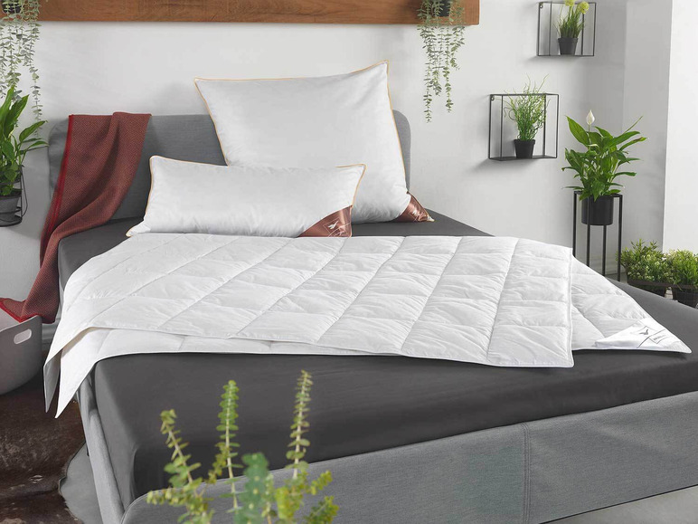 Een wit dekbed met twee kussens op een bed.