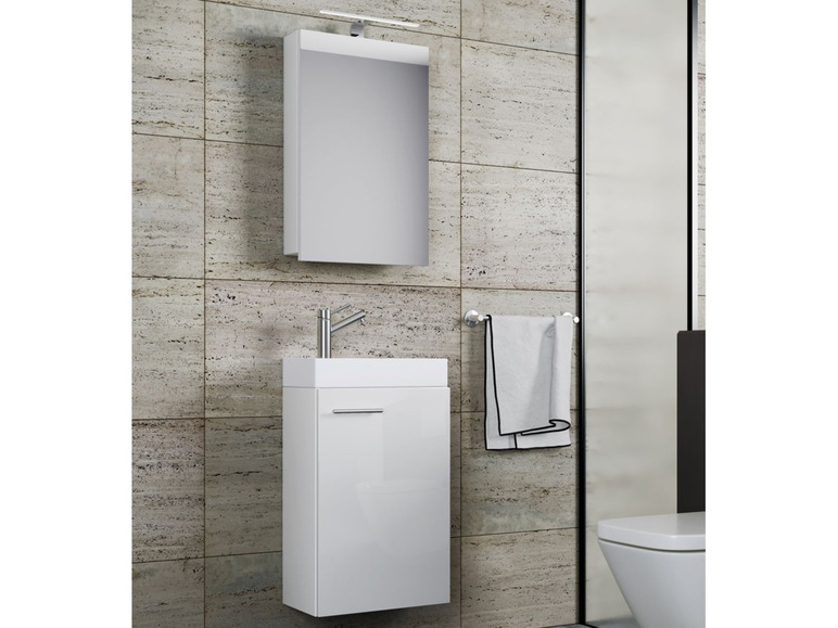 Wit badkamermeubel met spiegel en wastafel.