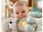 Een baby die een Fisher-Price pluche dier met licht en geluid vasthoudt.