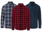 Drie langarm flanellen overhemden met ruitjespatroon in rood, blauw en groen.