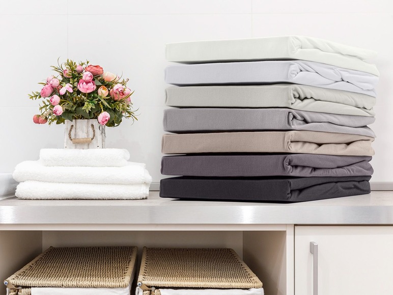 Een stapel bedlakens in verschillende kleuren.