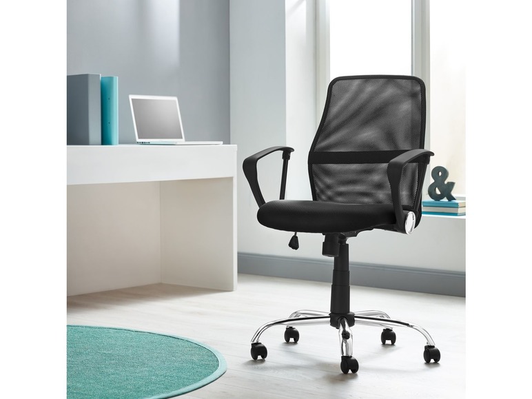 Een zwarte mesh bureaustoel met armleuningen en een laptop op een bureau.