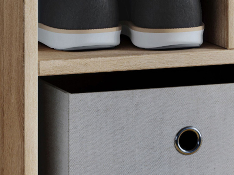 Een houten kast met een lade en een paar schoenen erop.