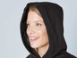 Een vrouw draagt een zwarte hoodie.