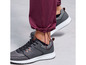Burgundy broekspijpen met zwarte sneakers.