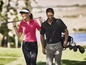 Twee golfers op de baan, een vrouw in een roze polo en een man met een zwarte polo en een golfbag.
