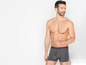 Man draagt ​​grijze boxershorts van het merk Never Stop.
