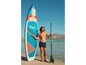 Man met een Crivit paddleboard en peddel op het strand.