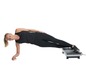 Een vrouw doet een plank oefening op een We-Vibe trilplaat.