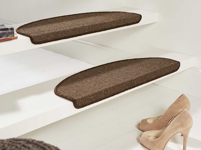 Twee bruine trapmatten met afgeronde hoeken op een witte trap.