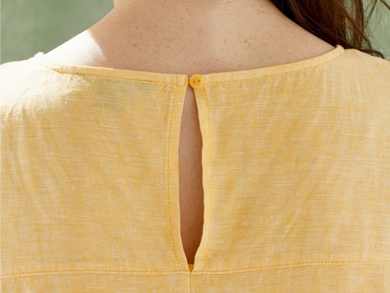 De achterkant van een lichtgele katoenen jurk met een knoopsluiting.