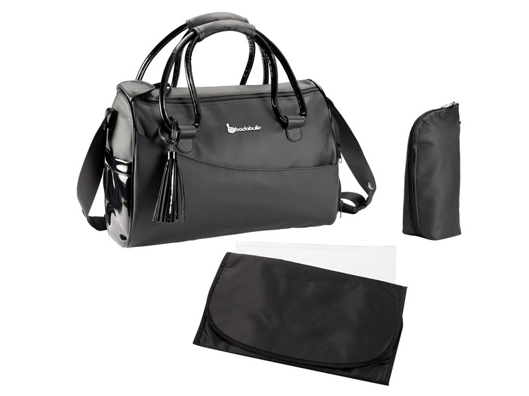 Een zwarte luiertas van Babybjörn met een bijpassend matje en een fleshouder.