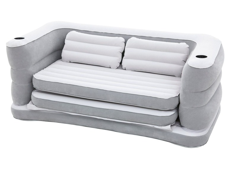 Een grijze opblaasbare slaapbank met twee kussens.