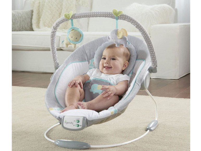 Een baby in een Ingenuity babyzitje met een olifantenthema.