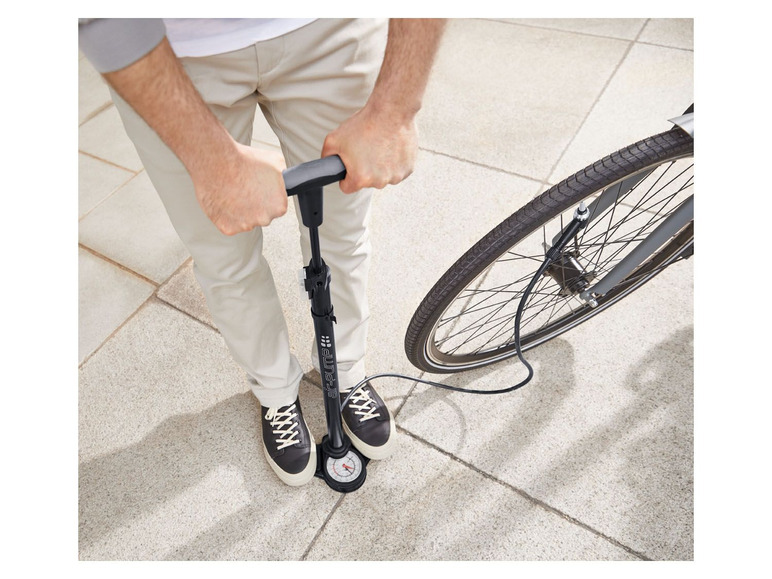 Een man pompt een fietsband op met een handpomp van het merk  WTB.