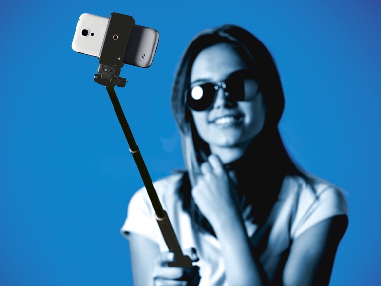 Een vrouw met een selfie stick en een smartphone