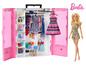 Barbie pop met kleding en accessoires in een roze kledingkast.