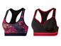 Twee sportbeha's: een met een roze-blauwe print en een zwarte met rode accenten.