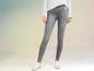 Grijze skinny jeans met witte sneakers.