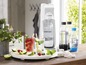 Sodastream-apparaat met flessen en glazen met frisdrank.