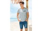 Man in een Miami Beachside t-shirt en jeans shorts op het strand.