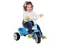Een kind rijdt op een blauwe Baby-Drive driewieler.