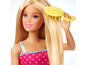 Barbie pop met lang blond haar wordt geborsteld.