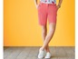 Vrouw in roze shorts en witte sneakers