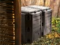 Twee zwarte compostbakken in de tuin