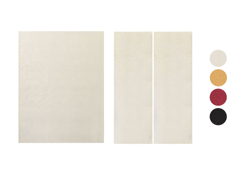 Drie witte placemats met een subtiel patroon.