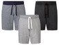 Drie paar korte broeken voor heren, grijs, zwart en grijs met donkerblauwe tailleband.