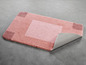 Een roze badmat met een antislip onderkant.