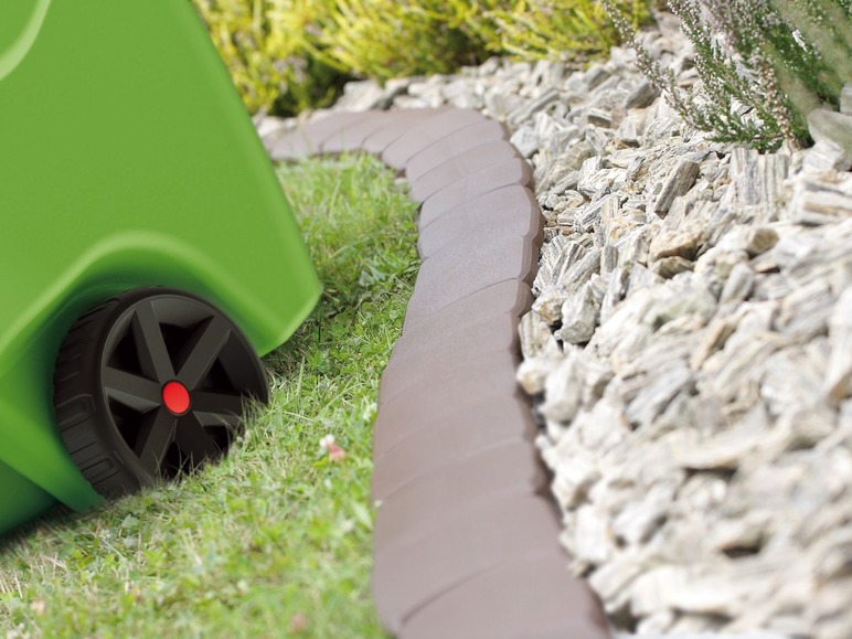 Een groene container met wielen naast een bruine randsteen voor de tuin.