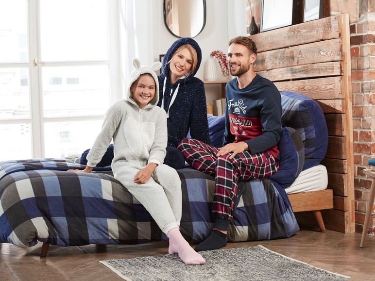 Een gezin draagt ​​comfortabele pyjama's in een slaapkamer.