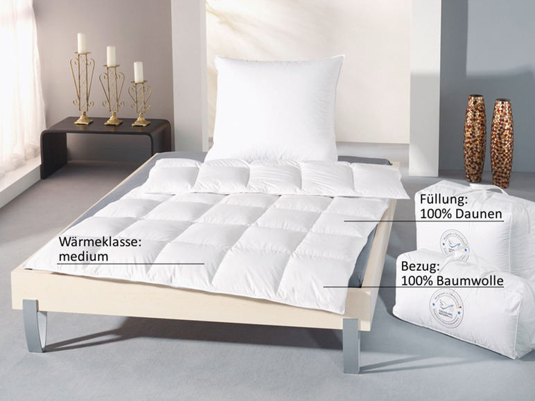 Een wit dekbed van dons met een katoenen hoes, gepresenteerd op een bed.