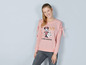 Een vrouw draagt een roze trui met een Minnie Mouse print.