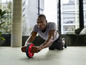 Een man gebruikt een ab-wiel voor een core-workout.