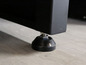 Een zwarte metalen voet met een zwarte plastic dop.