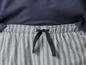 Een gestreept pyjamabroek met een donkerblauwe top.