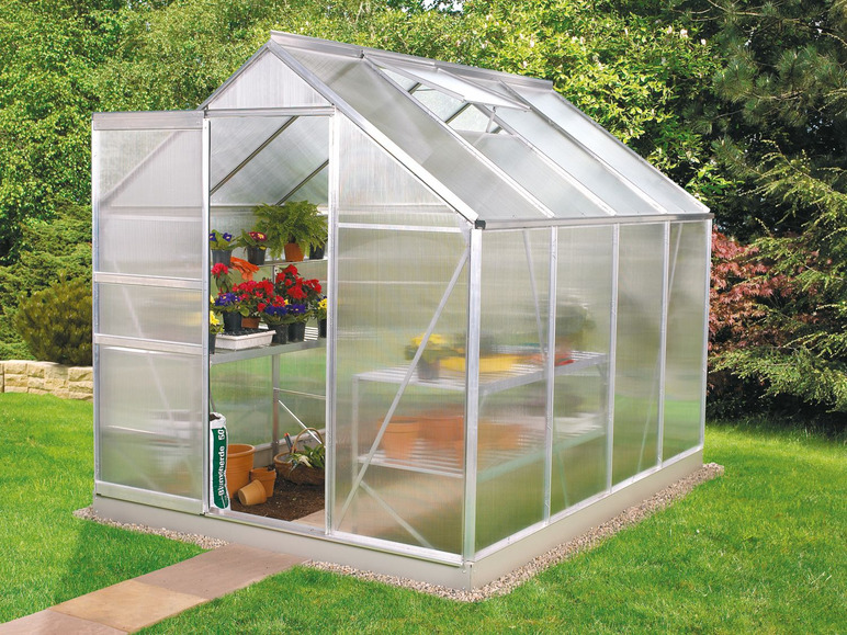 Een glazen kas met bloemen en planten.