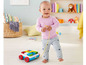 Een baby trekt een Fisher-Price blokkenwagen met blokken in verschillende kleuren.