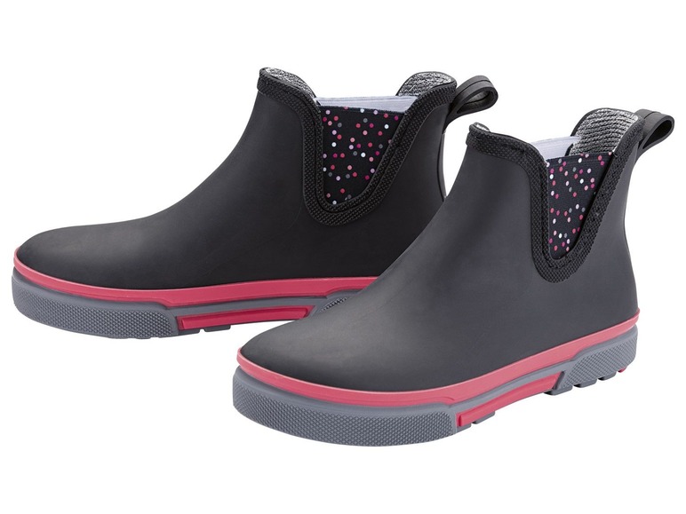 Twee zwarte regenlaarzen met roze accenten en stippen.