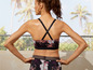 Een vrouw draagt een zwarte sportbeha en leggings met bloemenprint.