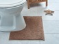 Een toilet met een bruine badmat.