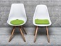 Twee witte stoelen met groene zitkussens
