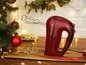 Een rode handmixer van Russell Hobbs, kerstversiering en koekjes.