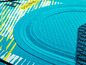 Een close-up van een turquoise paddleboard met een ruitpatroon en een 'Double Layer' label.